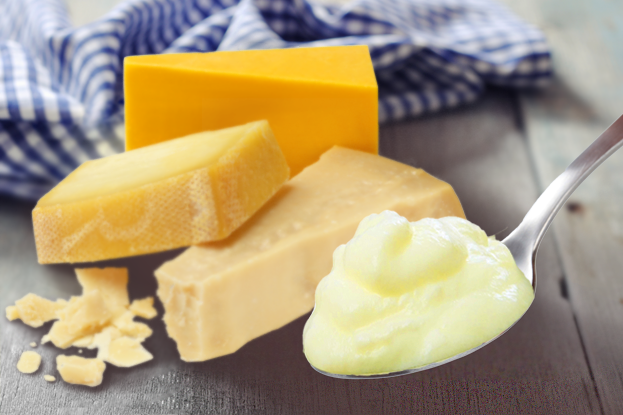 Cream-on-spoon-cheese-background